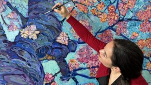 Erin Hanson painting a colorful tree on canvas